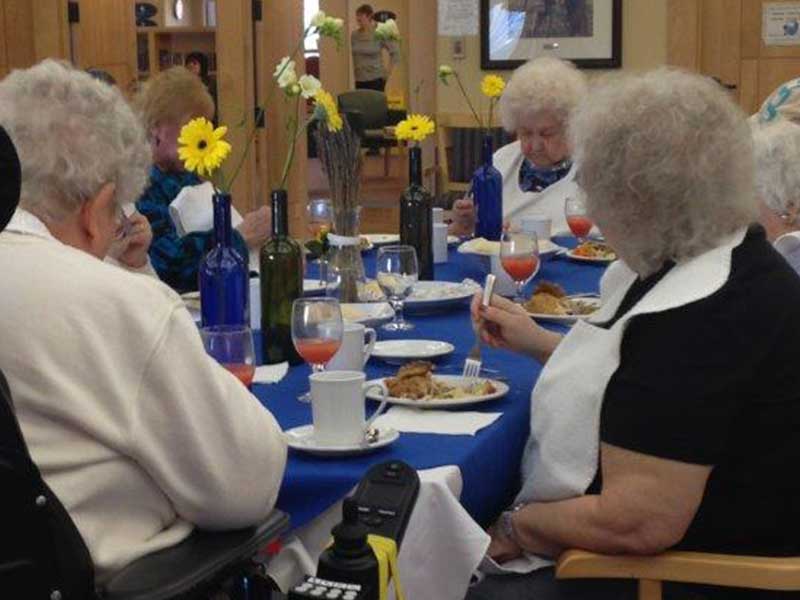 Residents gathered around a large table for a meal